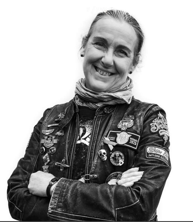 Cathy, vice-présidente de la FBF, bras croisés, blouson de cuir couvert de pins et de patchs