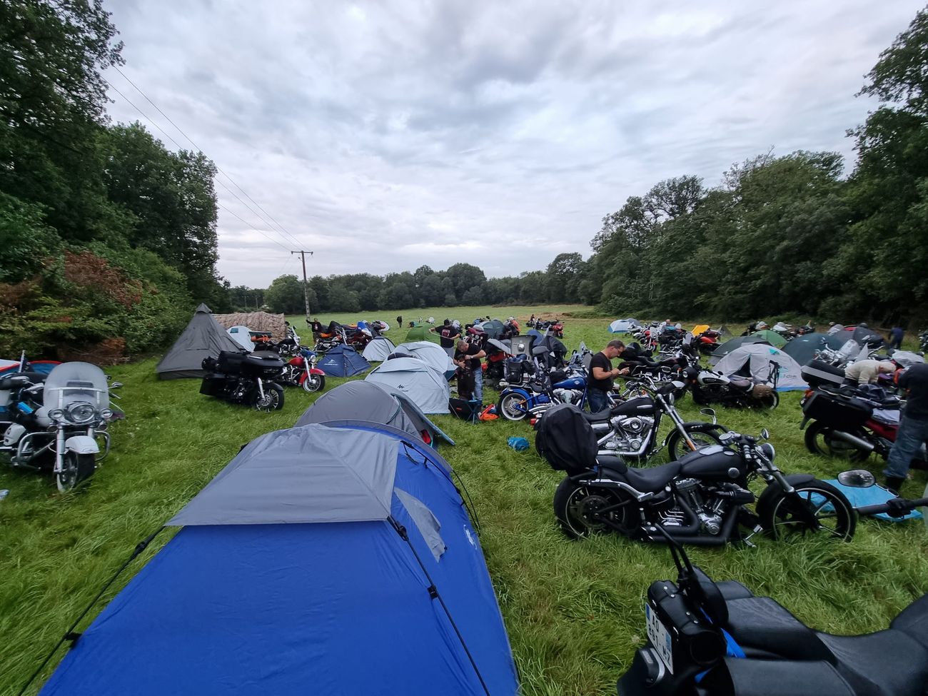 Le camp du run : tentes et motos mêlées dans un pré