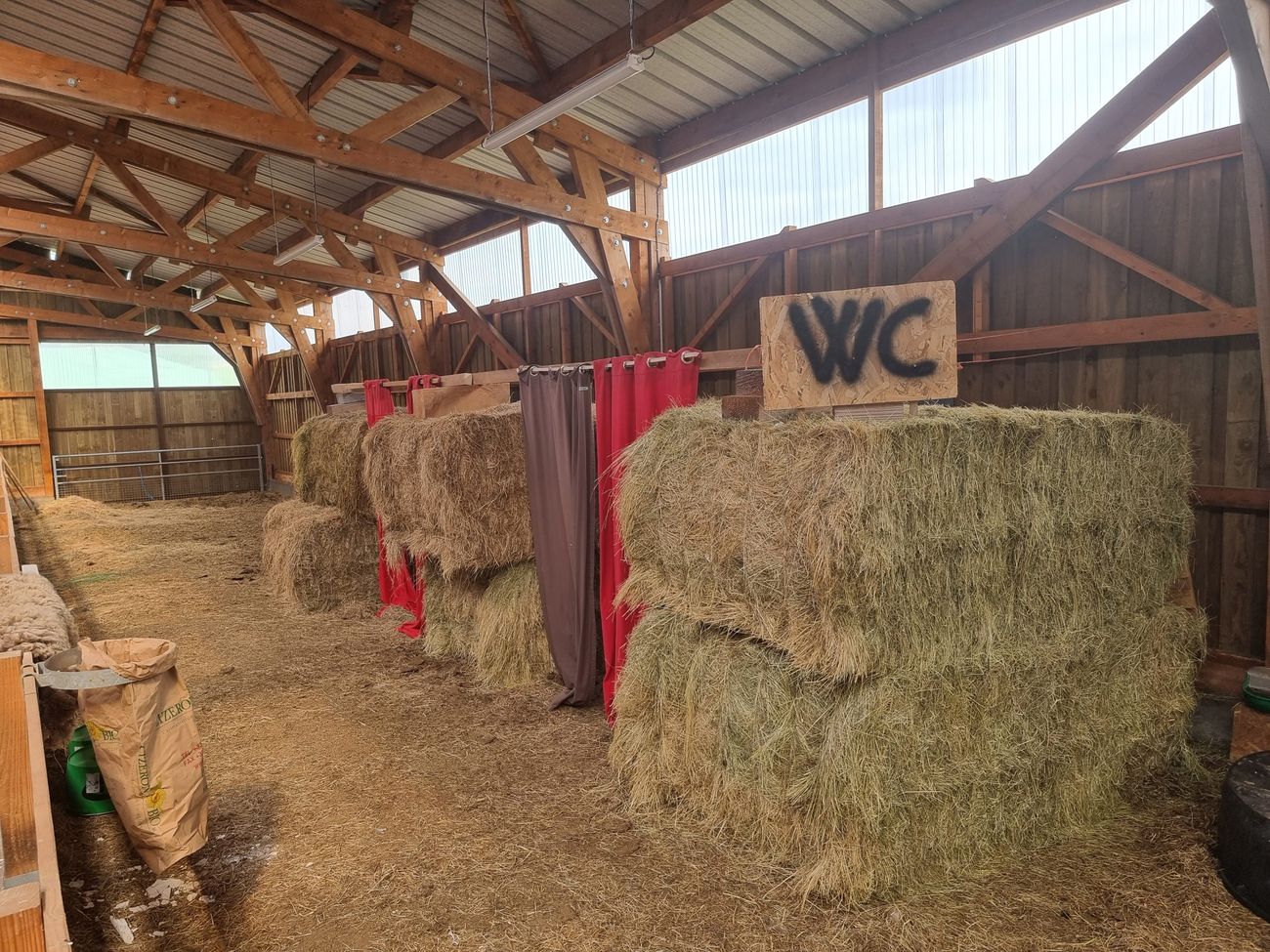 Toilettes installées dans une grange, entre les bottes de paille