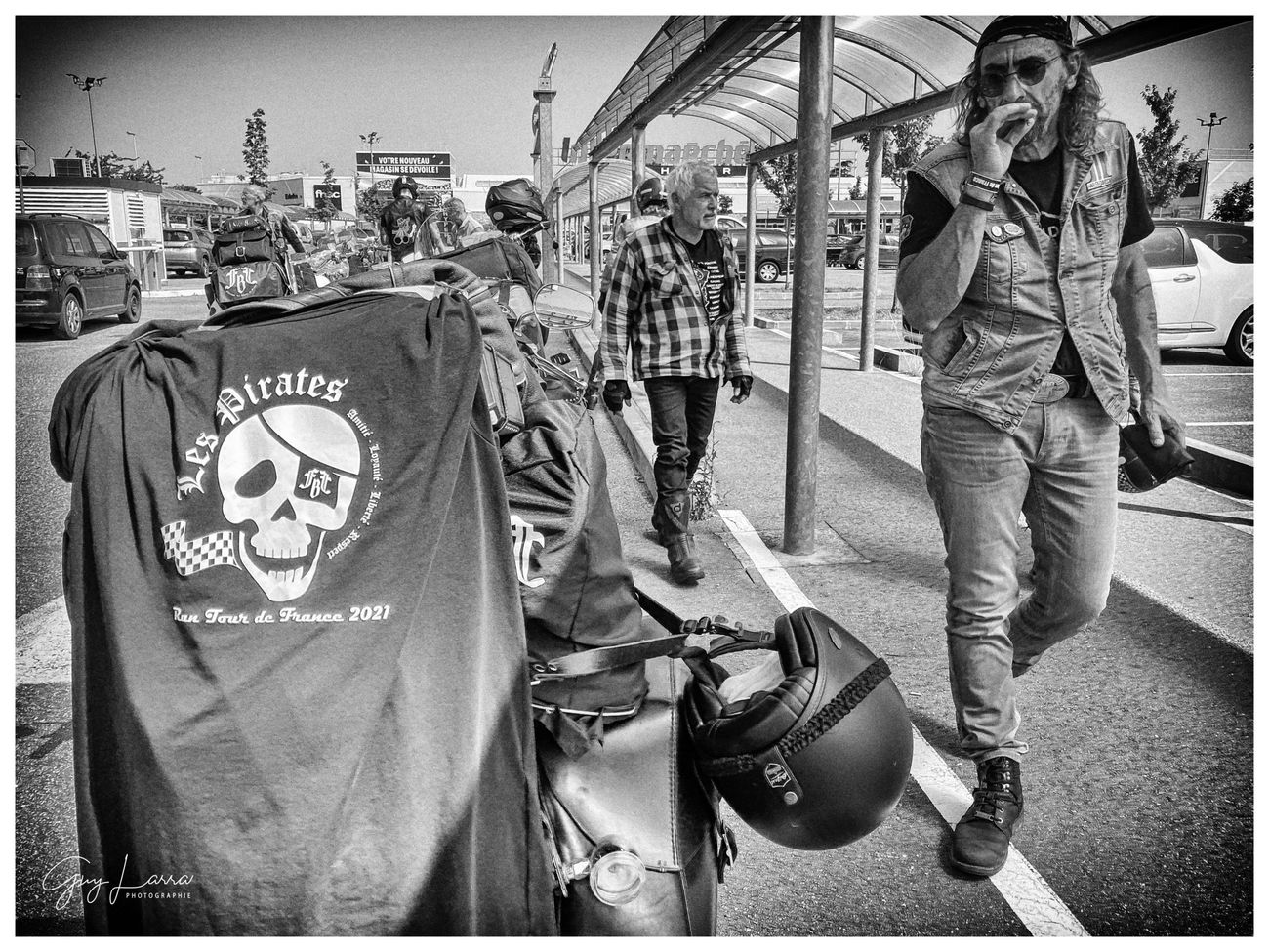 Un blouson aux couleurs d'un club posé sur une moto, un biker à côté